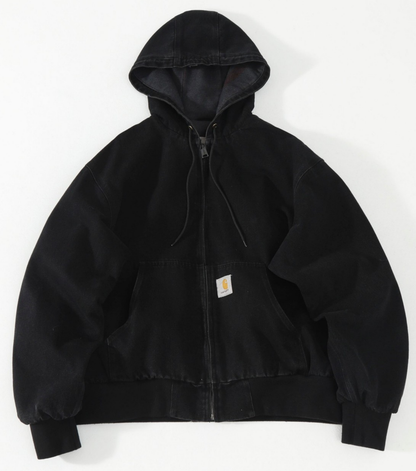 A black Carhartt hooded jacket with a front zipper, drawstring hood, and a small signature Carhartt label on the chest pocket, laid flat against a white background.