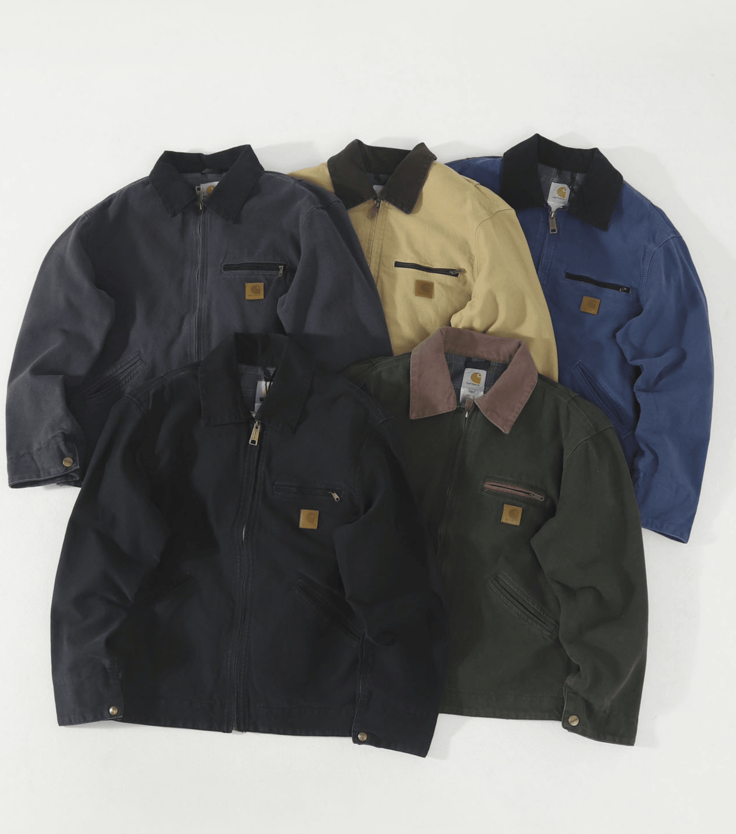 Five Carhartt work jackets in different colors (navy, tan, blue, black, and olive green) arranged in a fan shape on a white background.