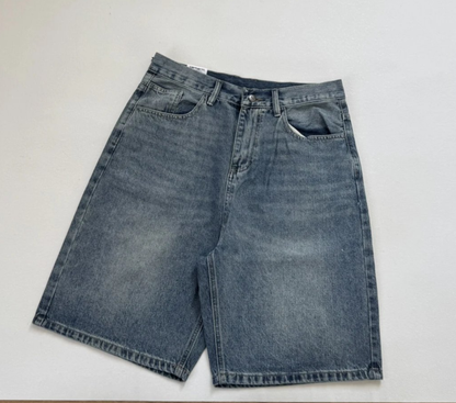 A pair of medium-wash blue denim shorts laid flat on a light gray background.